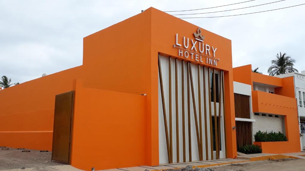 拉佩尼塔德加尔特姆巴Luxury Hotel Inn的一座橙色的建筑,上面标有酒店标志
