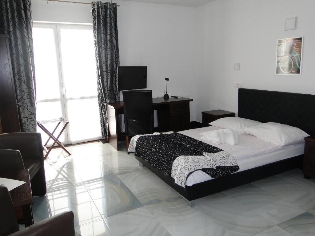 比得哥什阿加特SPA酒店的一间卧室配有一张床、一张书桌和一个窗户。