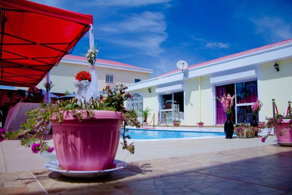 Talata-matyPetite Flower Guest House的一座带游泳池和红伞的房子