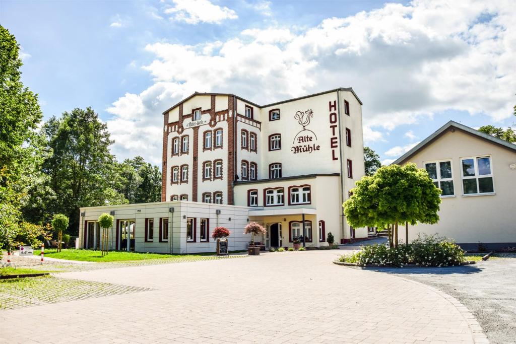 Rödental老磨坊餐厅酒店的前面有一棵树的白色大建筑