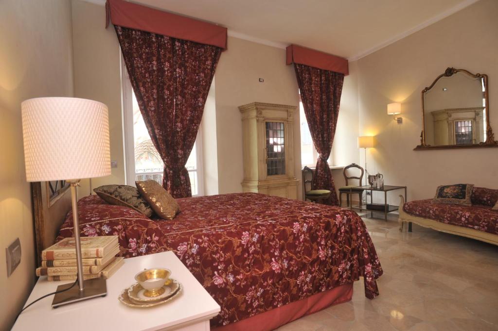 阿尔巴瑞莱斯阿尔倍儿圣多米尼克住宿加早餐旅馆的一间卧室配有一张床、一张沙发和一面镜子