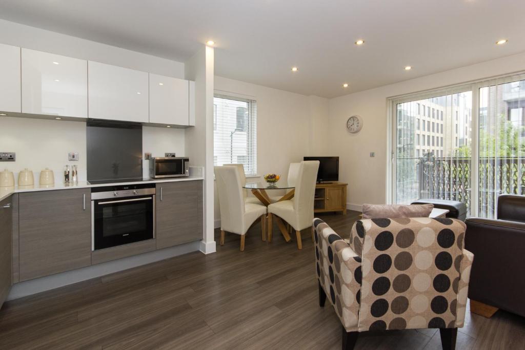 剑桥米尔公园城市住宿公寓的厨房以及带桌椅的起居室。