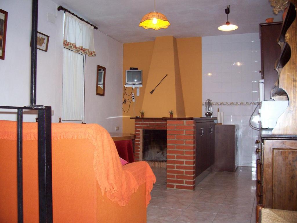Castaño de RobledoCasa Amigo的一间卧室配有橙色的床和壁炉
