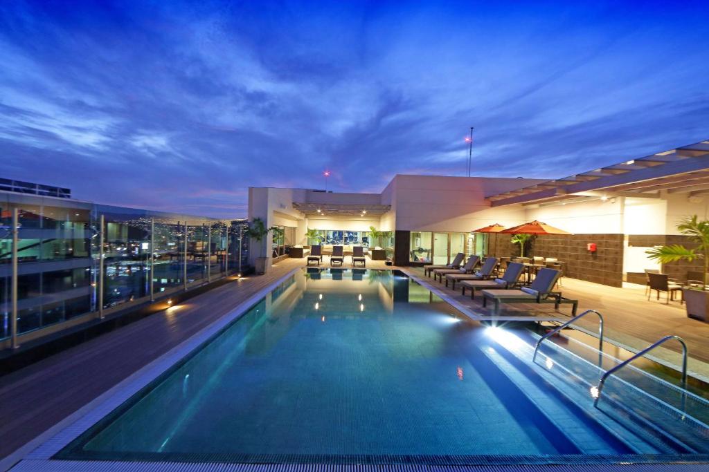 特古西加尔巴特古西加尔巴凯悦嘉轩酒店的夜间在建筑物屋顶上的游泳池