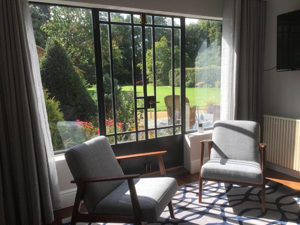 亨廷登Oak-Island Hall的客厅配有两把椅子和大窗户