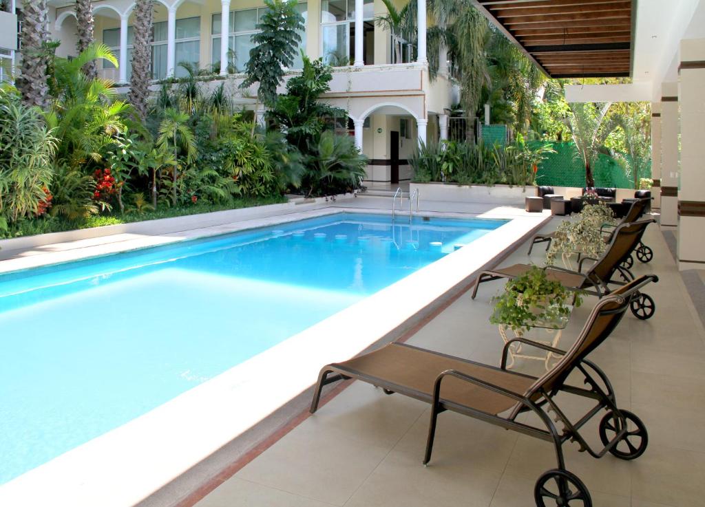 贾拉普维拉拉斯马格利塔卡科斯别墅酒店的游泳池位于酒店旁边,旁边设有两把椅子