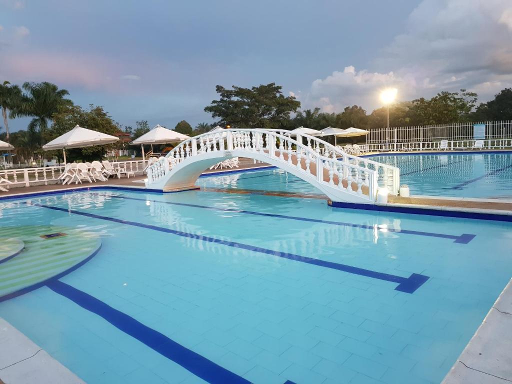 比亚维森西奥Hotel Campestre Kosta Azul的一座蓝色海水大泳池上的桥梁