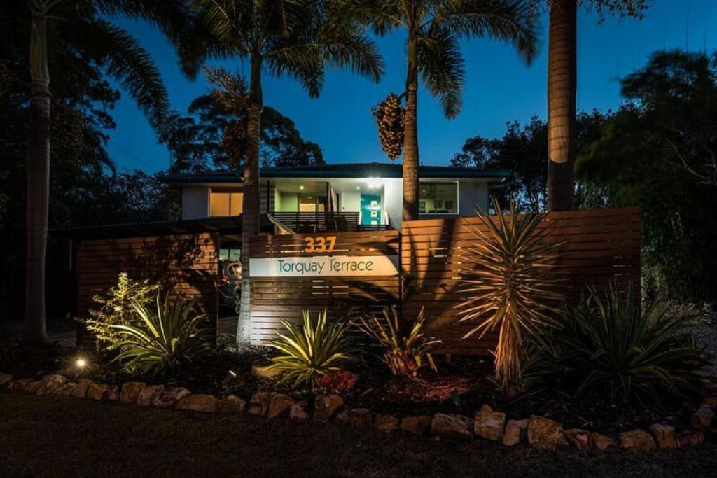 赫维湾托基特勒斯住宿加早餐旅馆的前面有棕榈树的房子