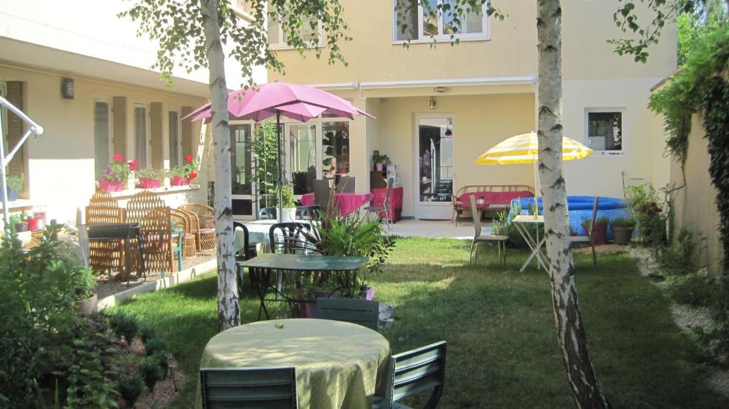 帕雷·勒·毛尼尔圣路易斯住宿加早餐旅馆的一个带桌椅和遮阳伞的庭院