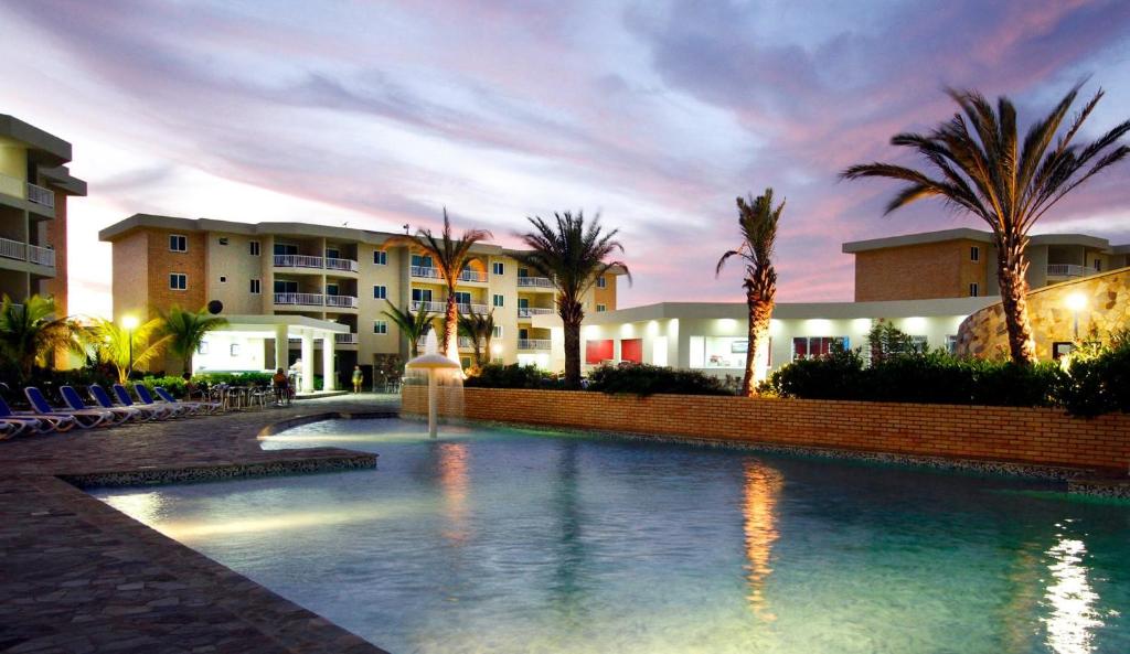 AltagraciaLD Suites Punta Playa的一座大楼前的游泳池,带喷泉