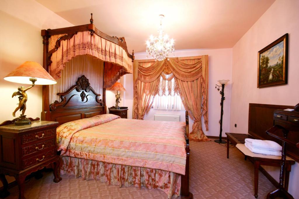 瓦尔纳Villa Dallas Residence的一间卧室配有一张大床和一个吊灯。