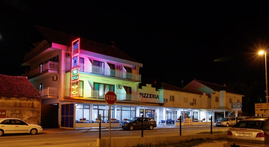 克宁Motel "Tri lovca"的明亮的建筑,前面有停车标志