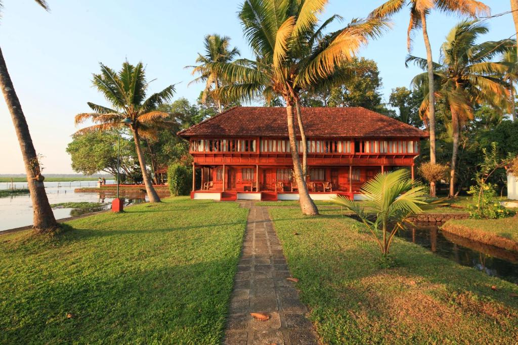 库玛拉孔Coconut Lagoon Kumarakom- CGH Earth的棕榈树草坪中间的房子