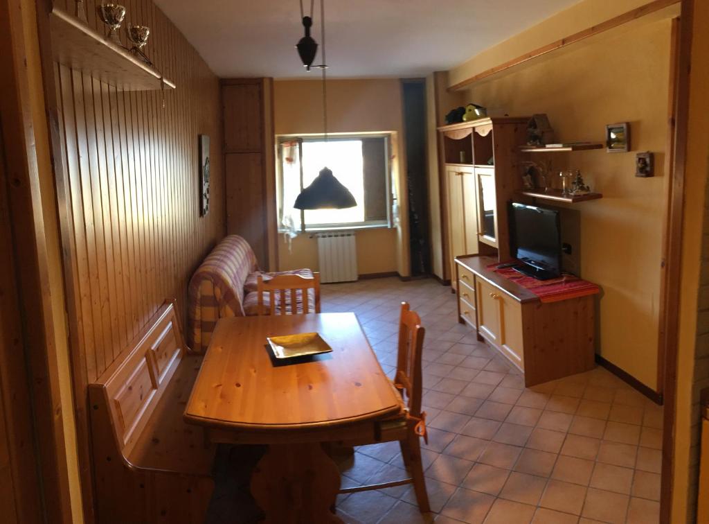 罗卡拉索Villaggio dello sciatore residence paradiso的客厅配有木桌和电视。