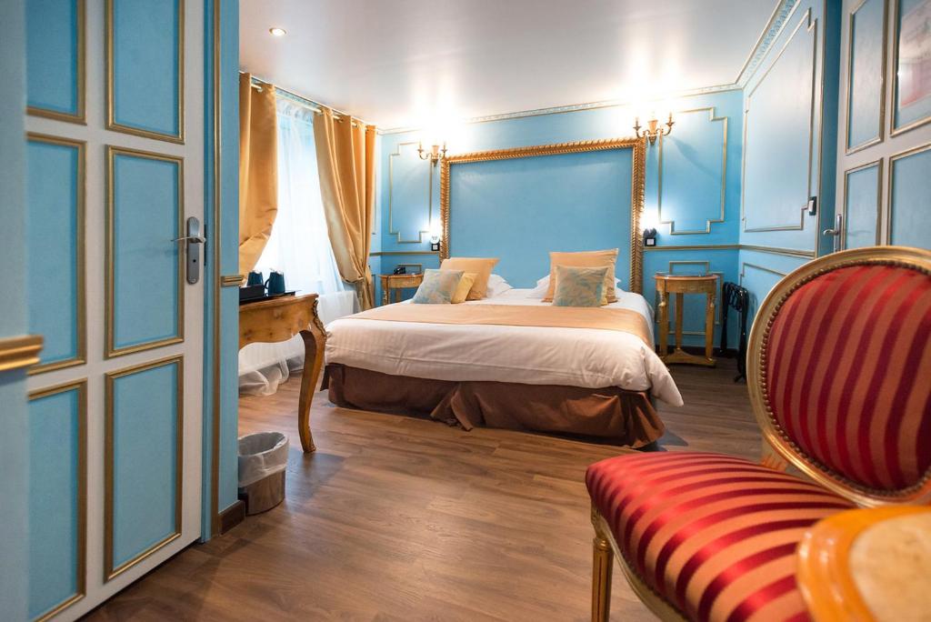 欧村Ault - Villa Aultia Hotel - baie de somme的一间卧室配有一张蓝色墙壁的床和一把椅子