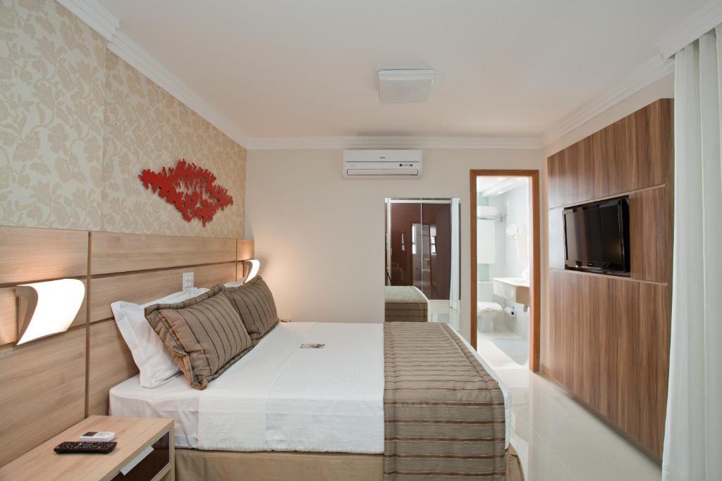 贝洛奥里藏特BH Jaraguá Hotel的酒店客房,配有床和电视