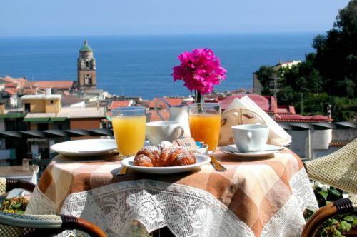 阿马尔菲劳拉别墅酒店的一张桌子,上面放着一盘食物和两杯橙汁