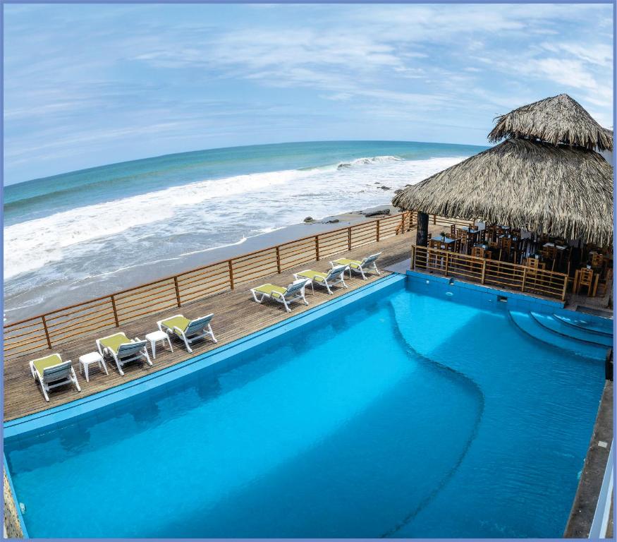 卡诺阿斯德蓬萨尔Akas Hotel Apartamentos的毗邻大海的游泳池,拥有海滩