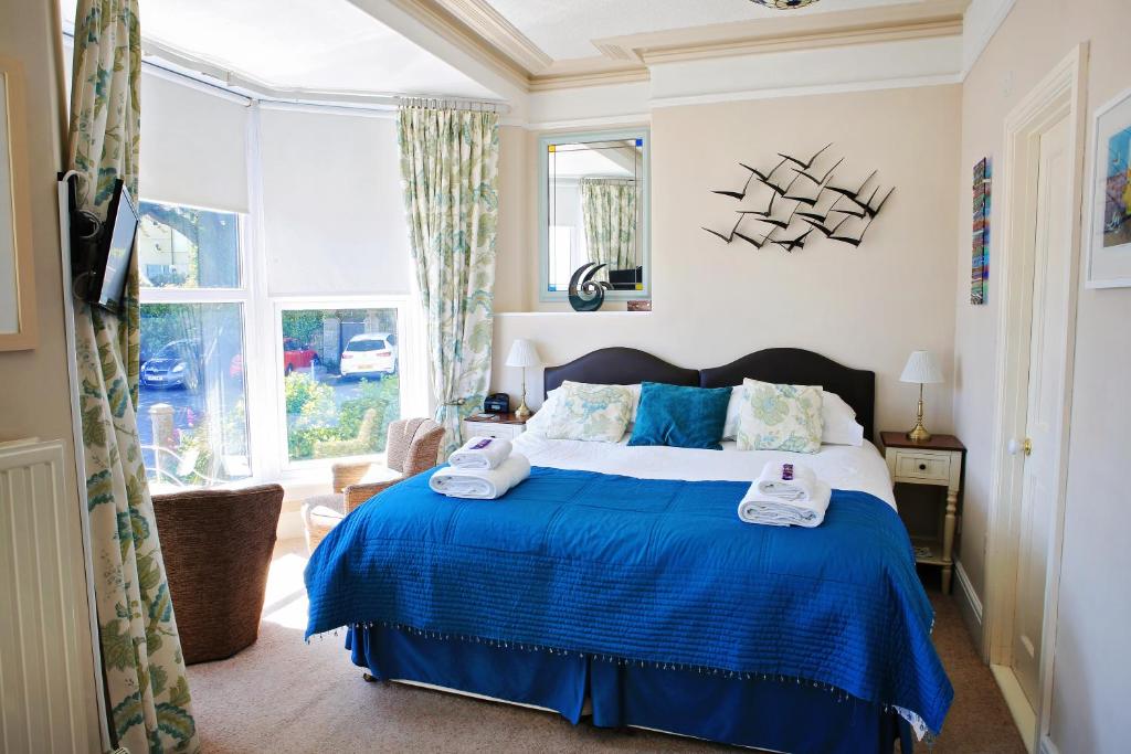 圣艾夫斯蓝天住宿加早餐旅馆的一间卧室设有蓝色的床和窗户。