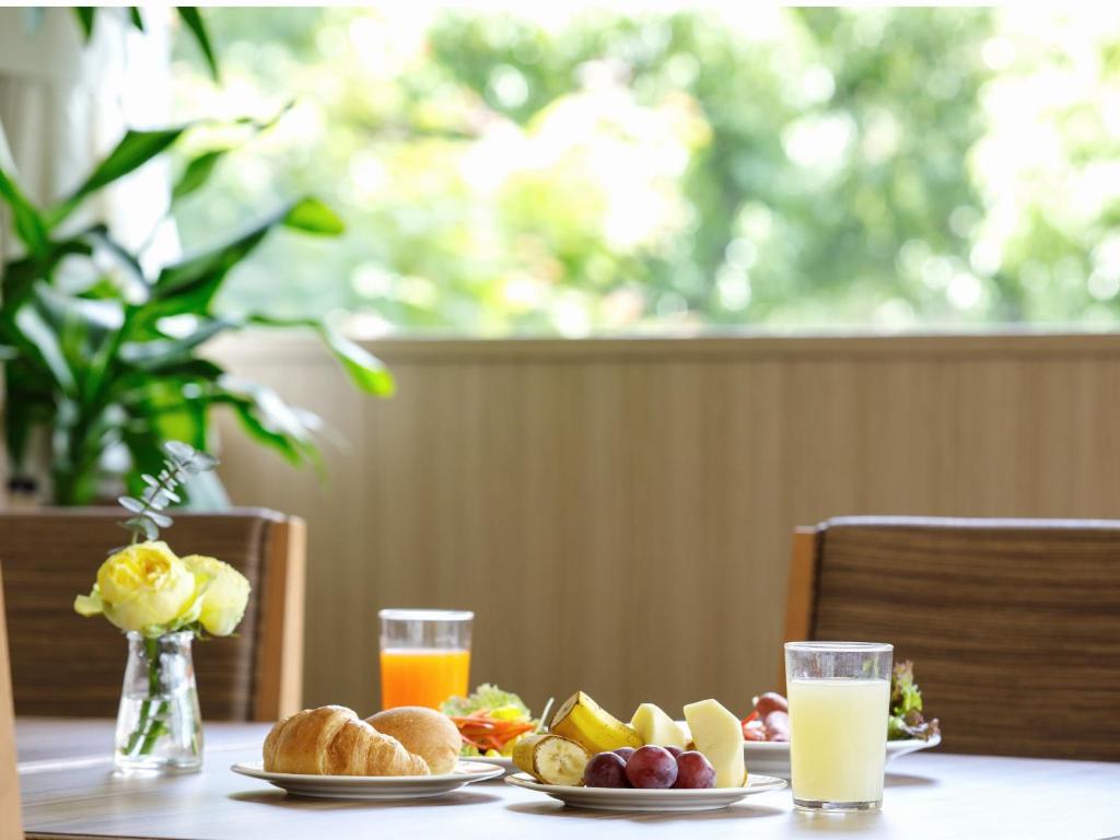 冈山冈山后乐酒店的餐桌,带食物盘和橙汁杯