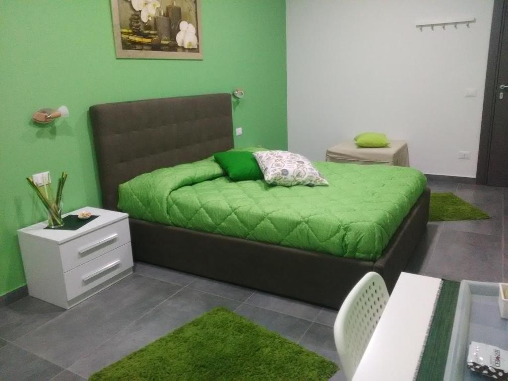 尼科洛西B&B La Grotta的绿色卧室配有一张带绿毯的床