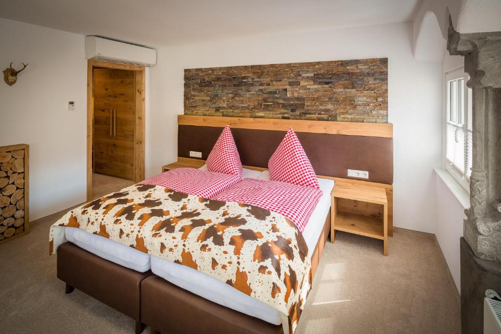 林道Hotel Alte Schule的一间卧室配有带粉色和棕色枕头的床