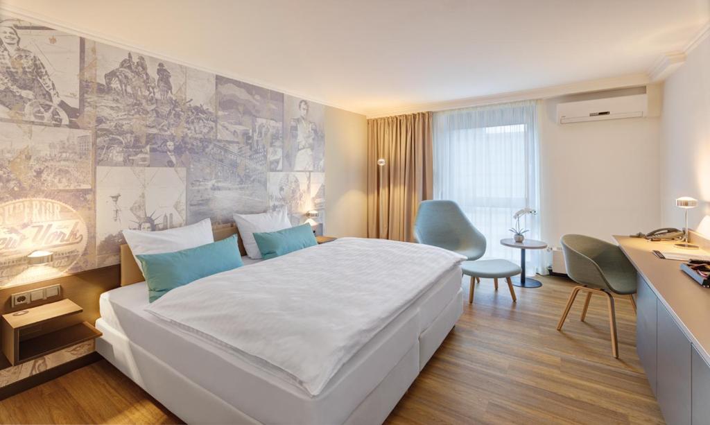 亚琛阿奎伊斯格拉德城市酒店的卧室配有一张白色大床和一张书桌