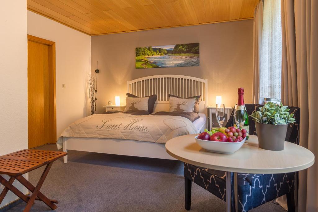 巴特哈尔茨堡Pension Trautheim的一间卧室配有一张床和一张桌子及一碗水果