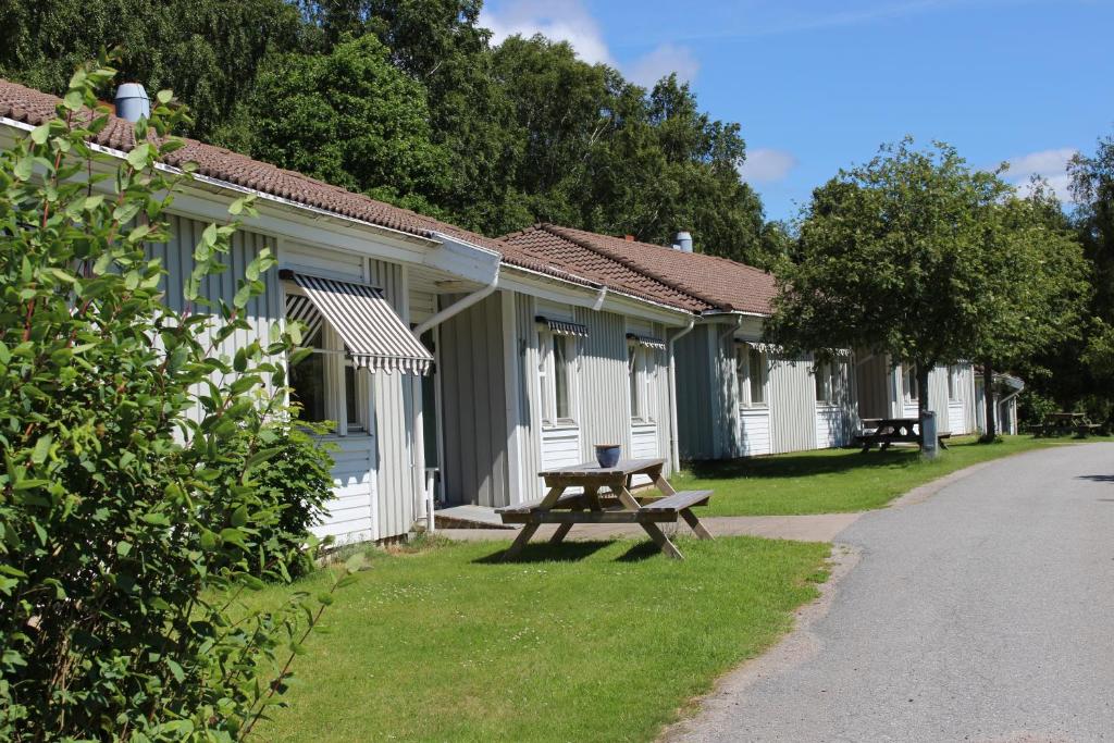 孔艾尔夫北欧民俗住宿加早餐酒店的草上一排带野餐桌的小屋