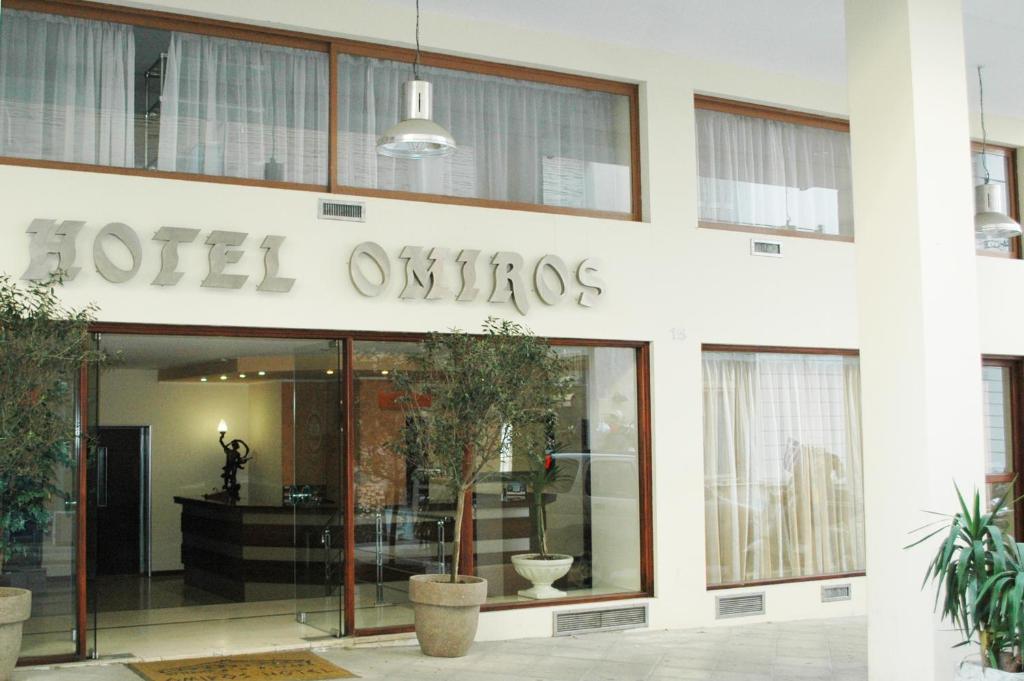 雅典奥米洛斯酒店的大楼一侧带有标志的酒店入口