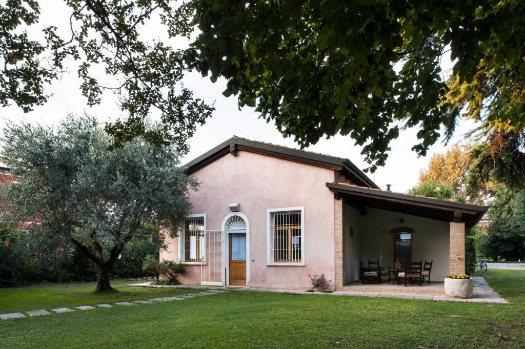 梅斯特Casa Lunia的一座带草地庭院的粉红色小房子
