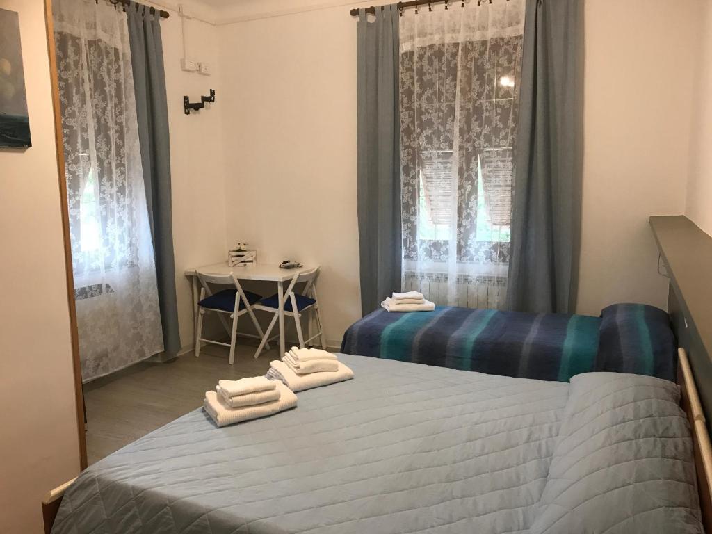 萨维尼奥内基娅拉酒店的一间卧室设有两张床,窗户上设有一张桌子。