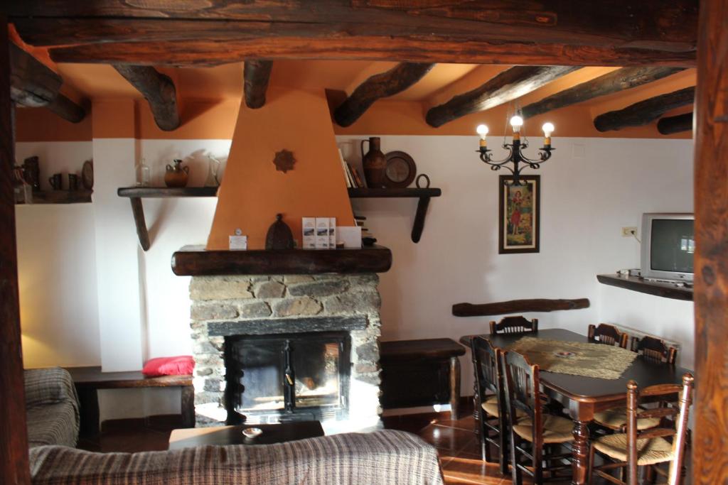 布维翁Casas Rurales Encarnita的客厅设有石制壁炉和桌子。