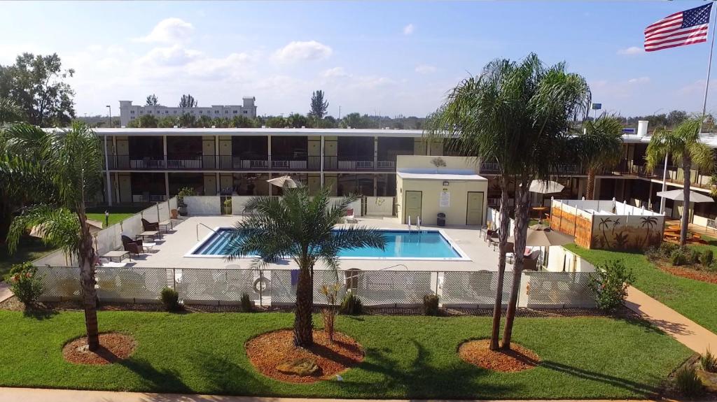 皮尔斯堡皮尔斯堡洪因酒店的享有带游泳池和棕榈树的建筑的空中景致