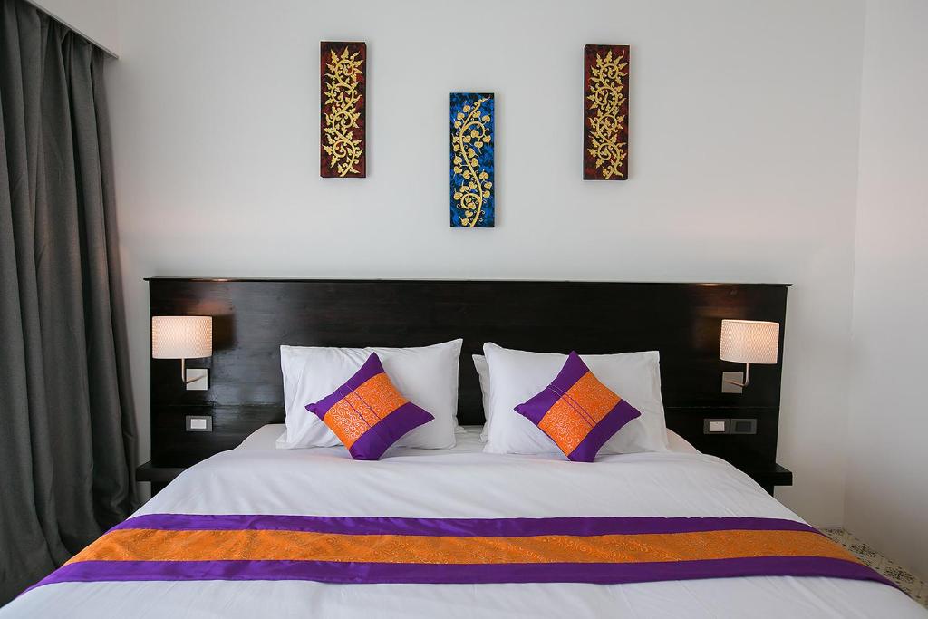 素可泰萨库斯迈尔度假酒店的卧室配有一张墙上三幅照片的床