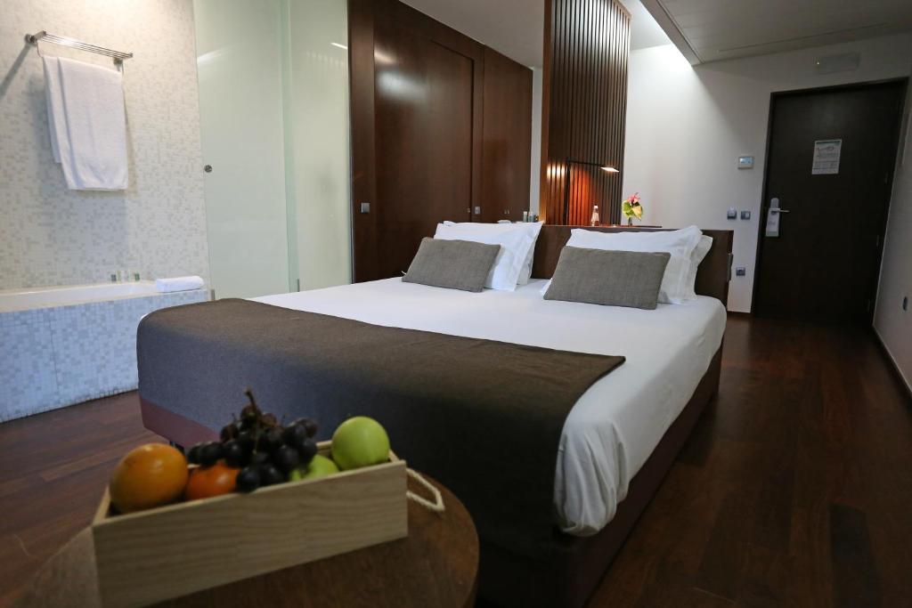 梅桑弗里乌Douro Scala的一张大床,位于酒店客房内,有一碗水果