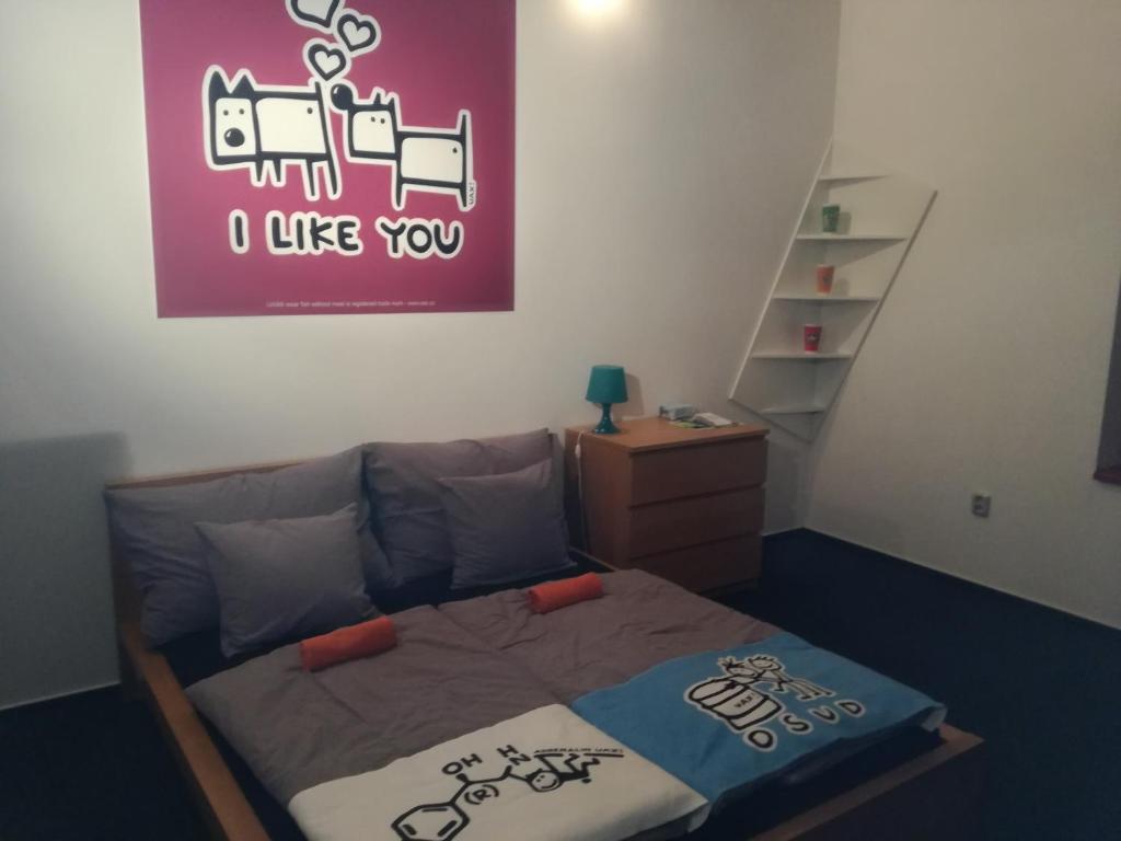 特罗亚诺维采Penzion UAX的卧室配有一张墙上紫色标牌的床