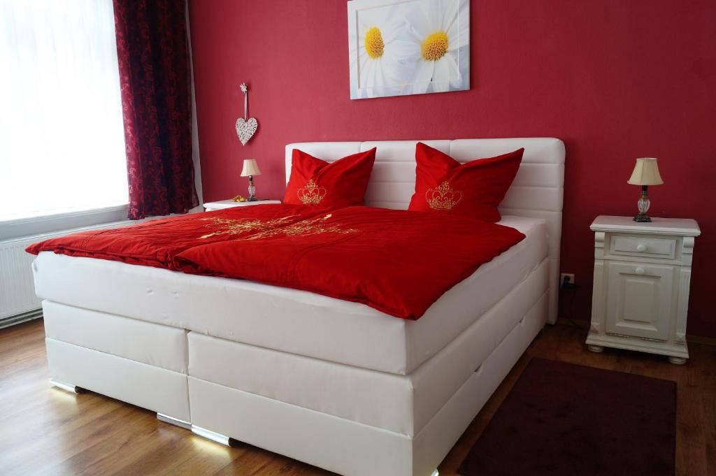 阿尔滕堡Ferienwohnung Schlossblick Altenburg的红色卧室配有白色的床和红色枕头