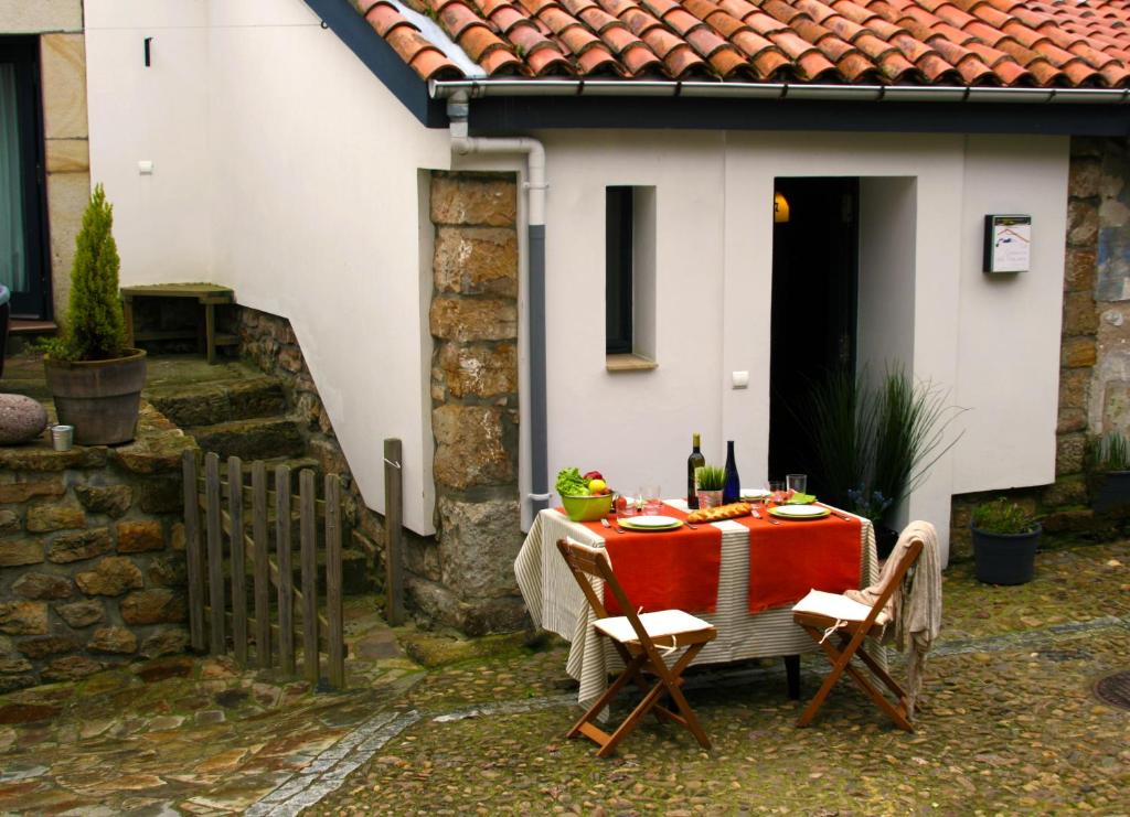 拉斯特雷斯Casa rural La Casona del Piquero的房子前面一张桌子上有一个红色的桌布