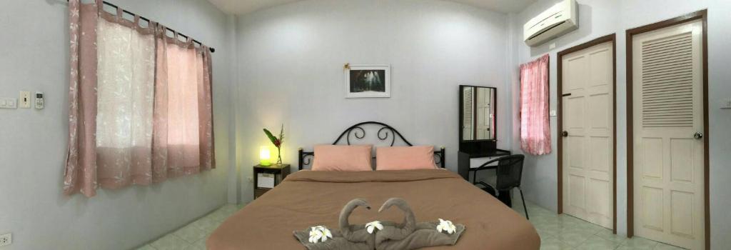 佛丕2N住宿加早餐旅馆的卧室配有一张带粉红色枕头的大床