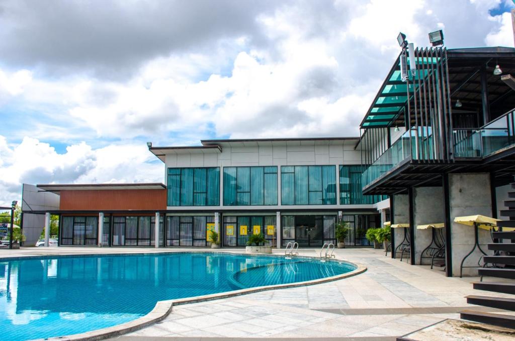 乌隆他尼普拉贾克特拉设计酒店的建筑前的一座带游泳池的建筑