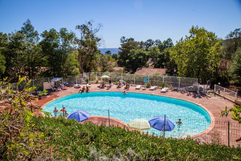 法沃内Vacancéole - Résidence Lisa Maria的游泳池配有遮阳伞,周围的人可以围着游泳池