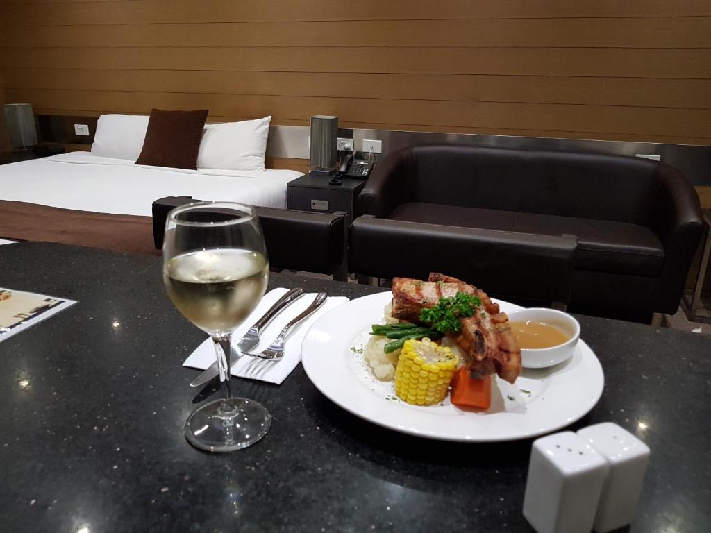 Moura毛拉梅瑞狄安汽车旅馆的一张桌子,上面放着一盘食物和一杯葡萄酒