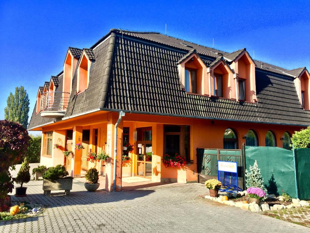 塞尼察Hotel Senica, Garni的一座大型橙色房子,屋顶黑色