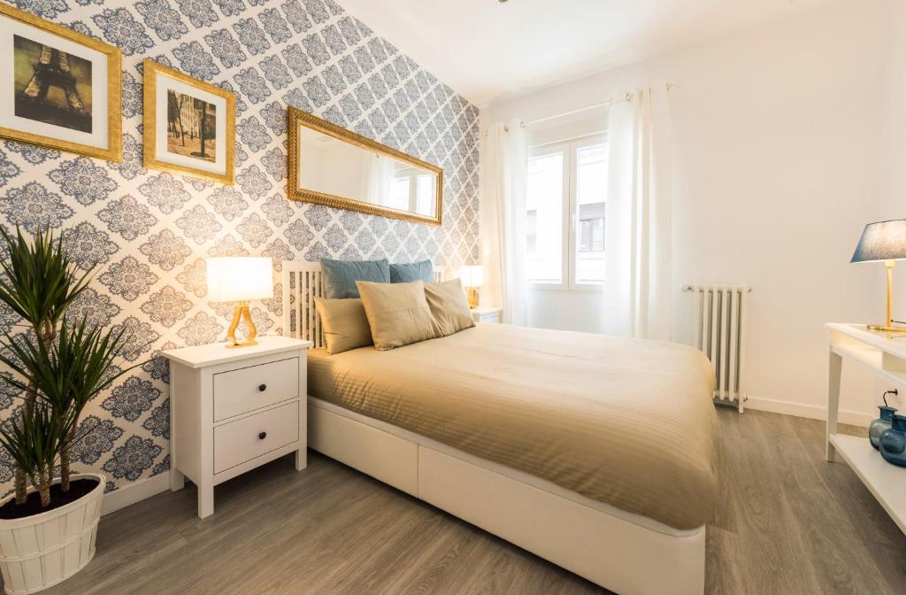 马德里古兹曼生活公寓的一间卧室设有一张大床和一个窗户。