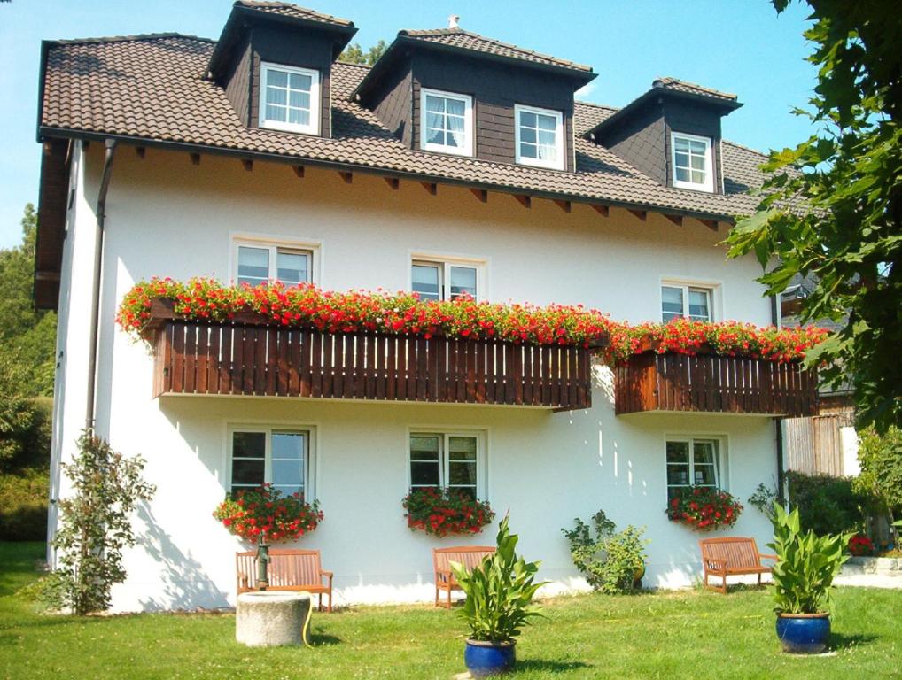 WeißdorfGasthof Pension Walther的阳台上的白色大房子,种着鲜花