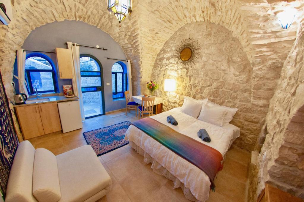 萨法德艺术区住宿加早餐旅馆的卧室配有一张石墙内的大床