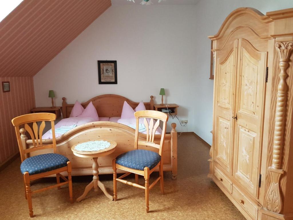 SpechtsbrunnGasthaus und Hotel Peterhänsel的卧室配有一张床和一张桌子及椅子