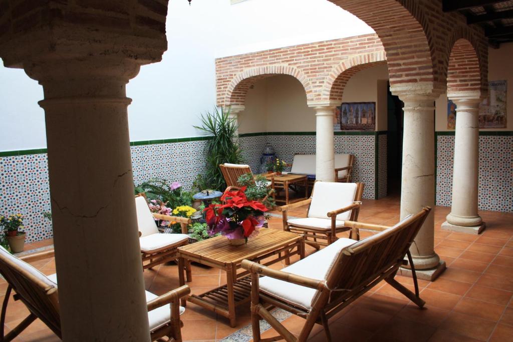 麦地那西多尼亚西多尼亚农舍乡村民宿的庭院配有椅子和鲜花桌子