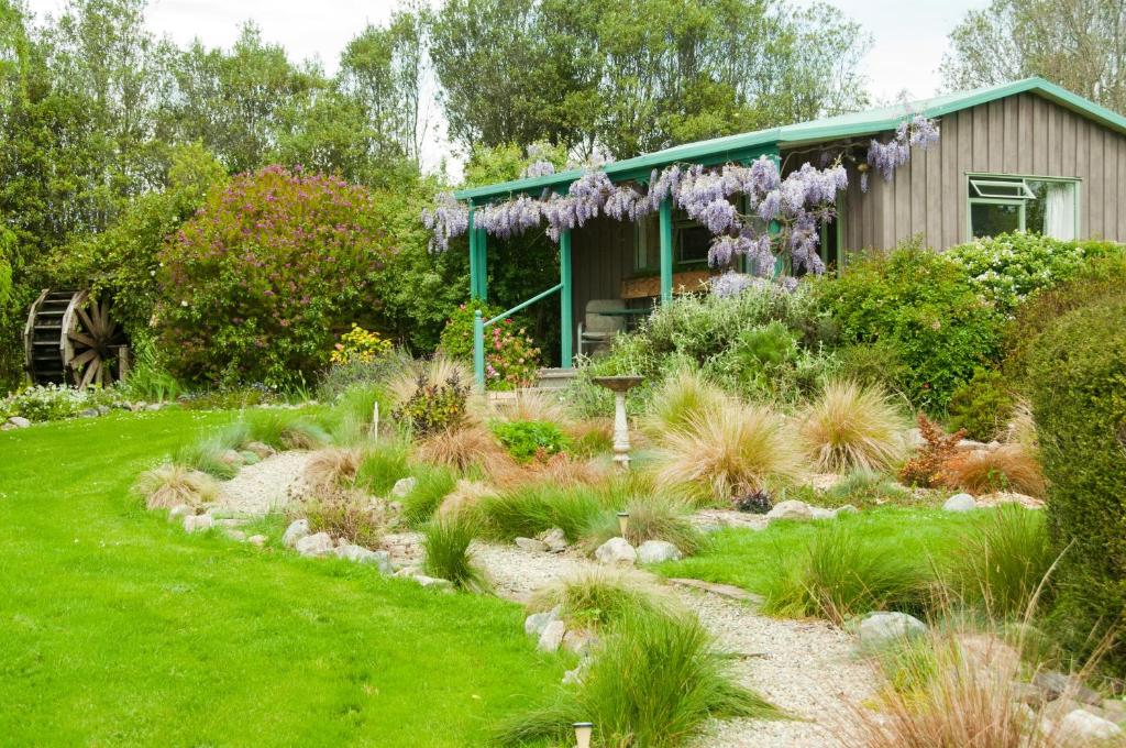 Upper Moutere水车度假屋的一座花园,花园内有一座紫色花卉的房子